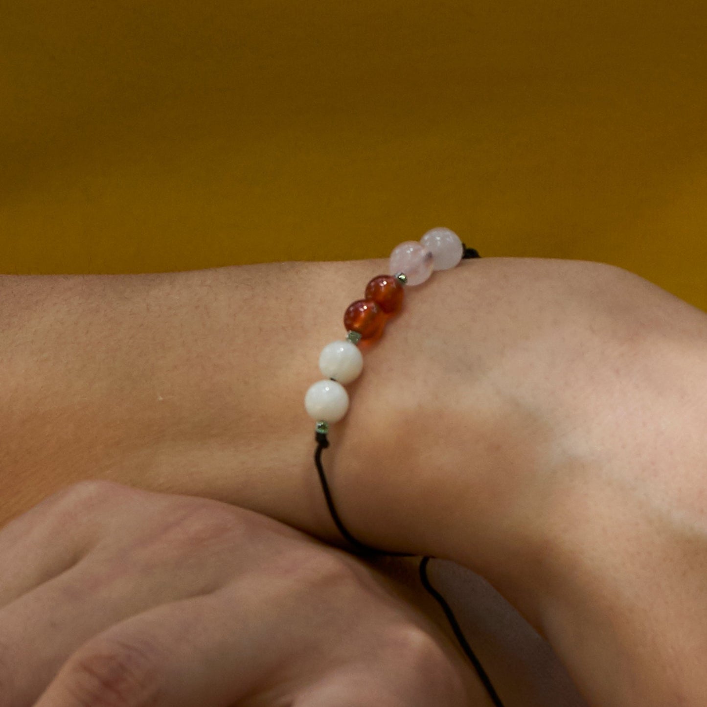 pulsera ajustable hecha a mano decorada con piedras naturales que promueven la fertilidad.