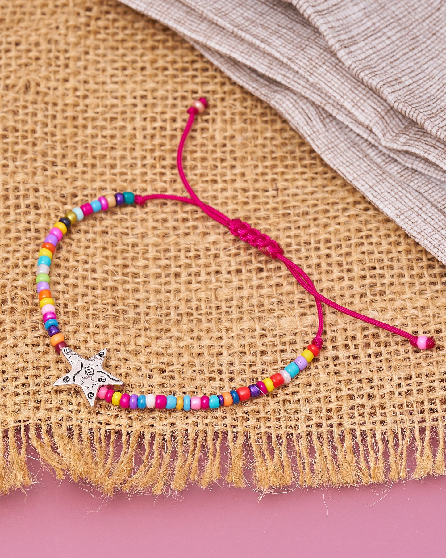 Pulsera de cuentas multicolores con estrella en plateado.