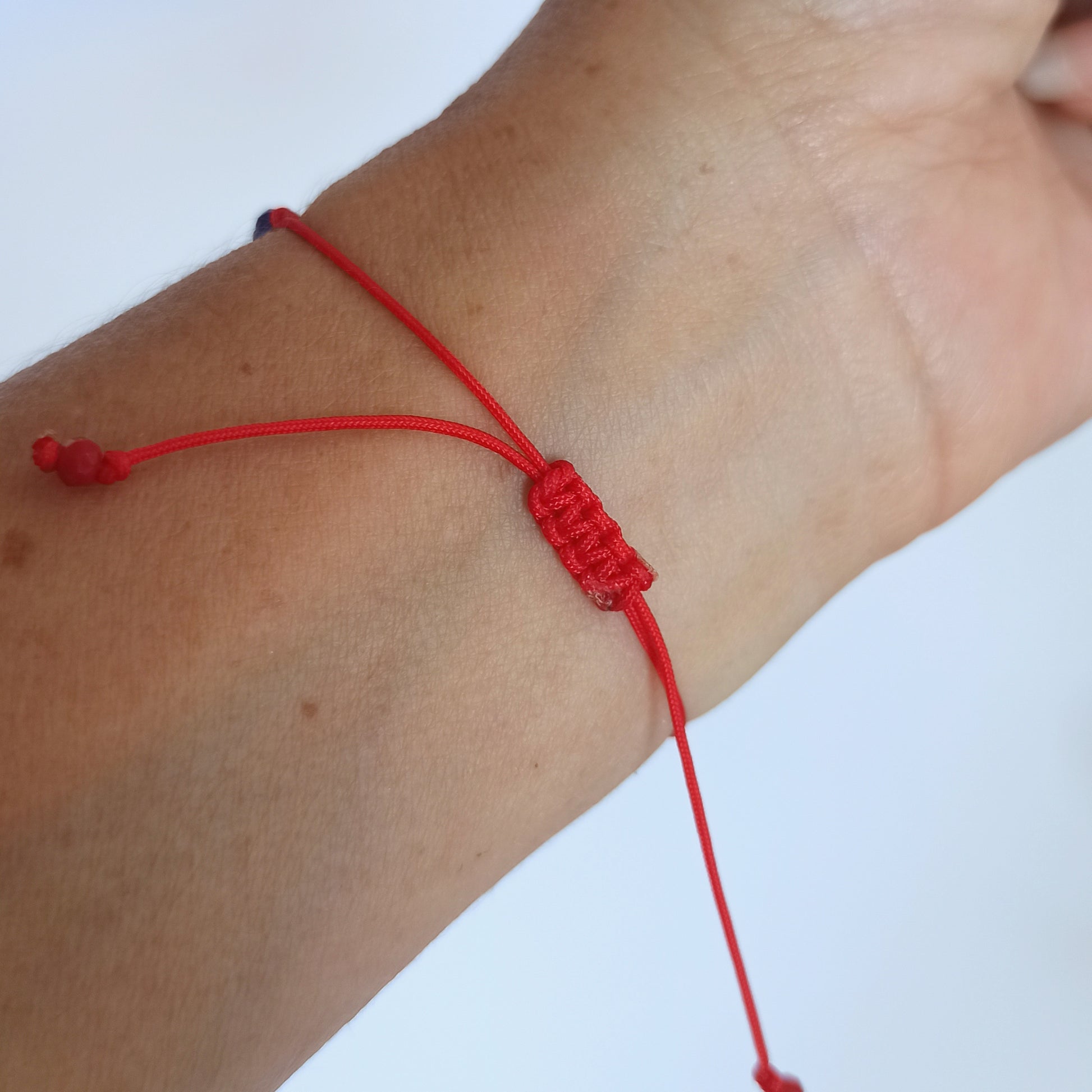 Pulsera de cordón rojo con nudo macramé que se puede deslizar fácilmente para quitar o poner cuando quieras.